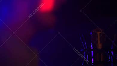 A stand-in microphone in nightclub with bright lights and backlit in the dark.