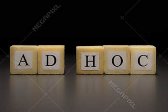 The word AD HOC written on wooden cubes isolated on a black background