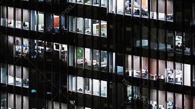 Time lapse of people working late night, office windows view on business center building facade