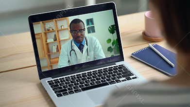 Telemedicine conference on laptop. Patient talk to African doctor from home. Coronavirus sick