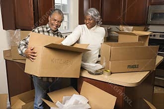 Middle-aged couple unpacking boxes.