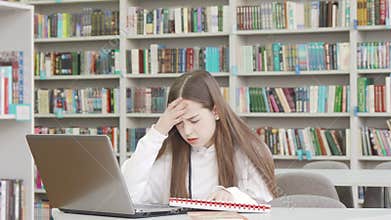 Teen female student stressing out while working on a project at the library