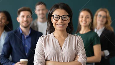 Happy female business leader standing in front of team