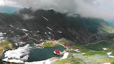 Beautiful mountain road and cabins in a foggy day