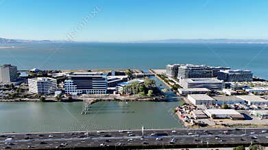 Aerial panoramic view of Meta Reality Labs in Burlingame, California, with San Francisco Bay, canal, highway, and distant skyline