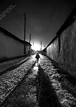 The girl is walking in the middle of the street.