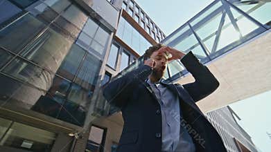 Annoyed manager quarrelling mobile phone on urban street. Stressed man calling