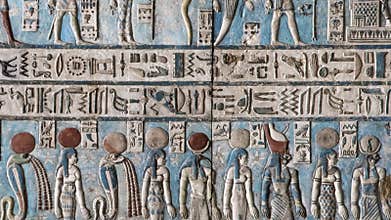 Ancient Egyptian hieroglyphs and bas-reliefs close-up in Dendera temple or Temple of Hathor. Egypt. Dendera Temple