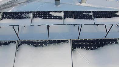 Snowy solar batteries at winter sunny day. Aerial
