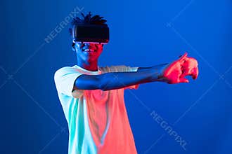 African sport player wearing VR stretching arm neon light wall. Contrivance.