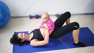 Young mother doing exercises with her daughter in