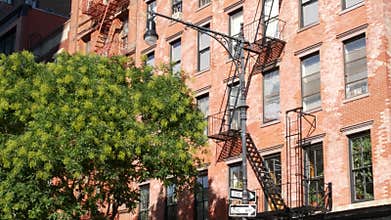 New York City building architecture, Manhattan. Residential house exterior. Red brick, fire escape.