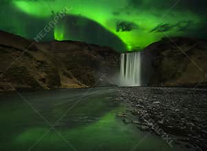 Flash of Aurora polaris above waterfall