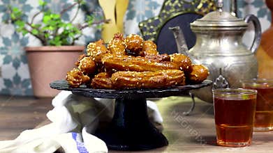woman pouring a honey sirup on algeria oriental Balah el sham dessert fritters named zlabiat al banan