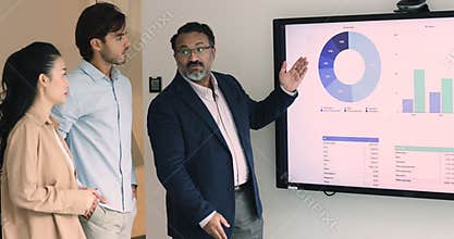 Middle-aged Indian boss explain sales analytics data to employees