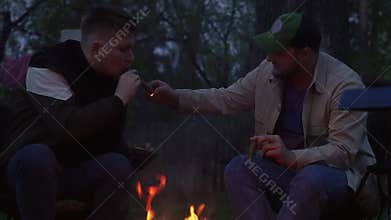Two guys are lighting cigars.