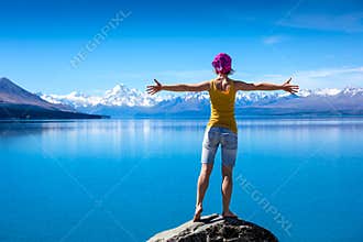 Girl is standing on top of the rock and enjoying the view
