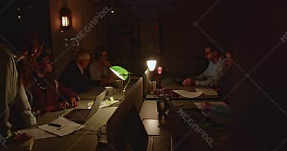 Dedicated team of businesspeople working late in an office, brainstorming over new strategies.