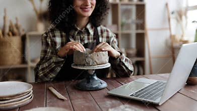 Woman sculpting pottery clay in ceramics studio