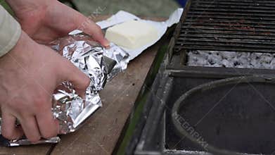 The steak in foil is placed on the grill.
