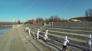 Seven members of sports team jump by stone