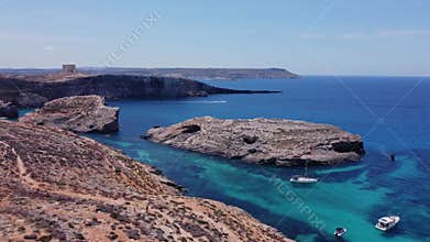 Natural windows in the rocks, Comino Island Malta, Aerial view. Boats moored in the crystal clear sea water