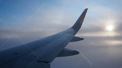 Istanbul, Turkiye - January 24, 2026: Pegasus Airlines Plane Wing Over Evening Clouds. Sunset Peeking Through Haze. Aircraft