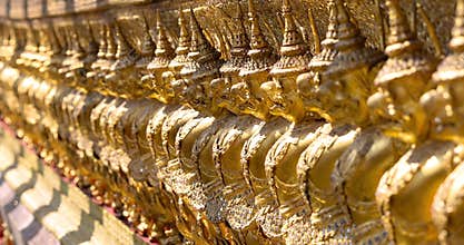 Row of guardian Garuda golden statues at the Temple of the Emerald Buddha in Grand Palace, Thailand