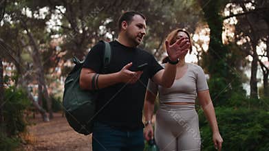 Couple hiking together in a forest park at sunset