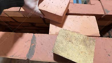 A man is constructing the ceiling of a fireclay heating stove core