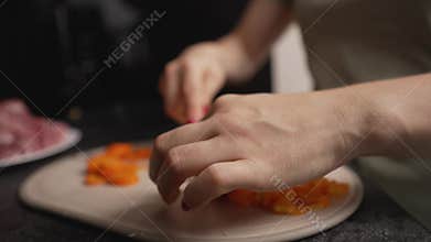 Woman chopping carrots on cutting board