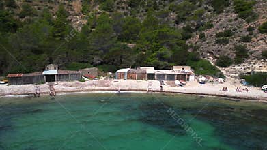 Turtle at Wooden boat houses on the beach Ibiza. Best aerial view flight drone