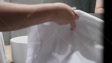 A woman in a bathroom with a towel reflects tranquility hands wash