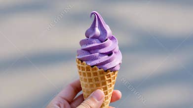 Lavender-colored soft serve ice cream in a crisp waffle cone