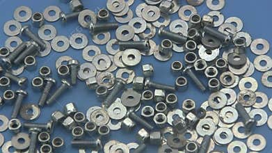 Nuts, washers and bolts rotating on a blue background.