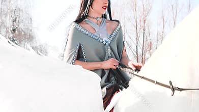 Attractive girl with black long hair and a gray cloak went hunting on a white pegasus with wonderful wings, the fairy