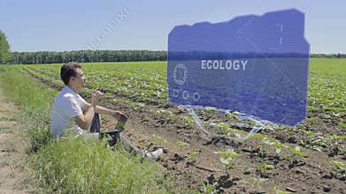 Man is working on HUD holographic display with text Ecology on the edge of the field