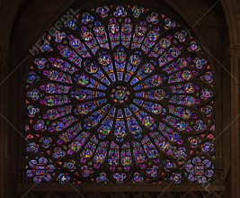 Closeup of stained glass of the oldest rose window installed in 1225 in the Notre Dame de Paris Cathedral in Paris France