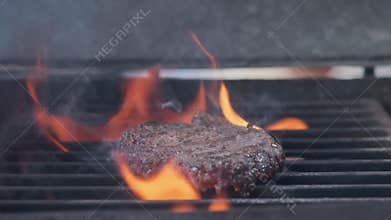 Cooking hamburger. Beef or pork cutlet grilling on grid. Cook man preparing a burger patty on the grill. Laid on the