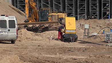 Worker man pouring diesel fuel into generator and highway constructing works