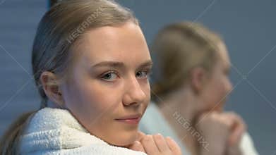 Beautiful female teenager applying face cream, beauty care for young skin