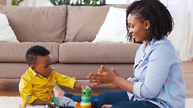 Mother and baby playing with toy blocks at home