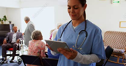 Front view of Caucasian female doctor using digital tablet at nursing home 4k
