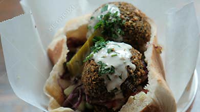 A dish of falafel in a paper napkin on the table.