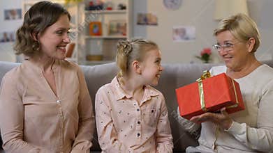Family giving present to granny, celebrating birthday together, love and care