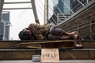 Beggar or Homeless man sleep in city at winter