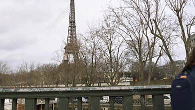 Kids coming back to from school walking on Pont de Bir-Hakeim with Eiffel Tower