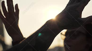 Happy friends giving high five to hand during during farewell or greeting