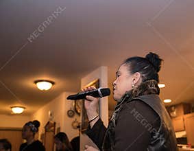 Asian woman singing karaoke at a party