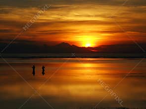 Fishing at dawn under an incredible orange sunrise, Bali.